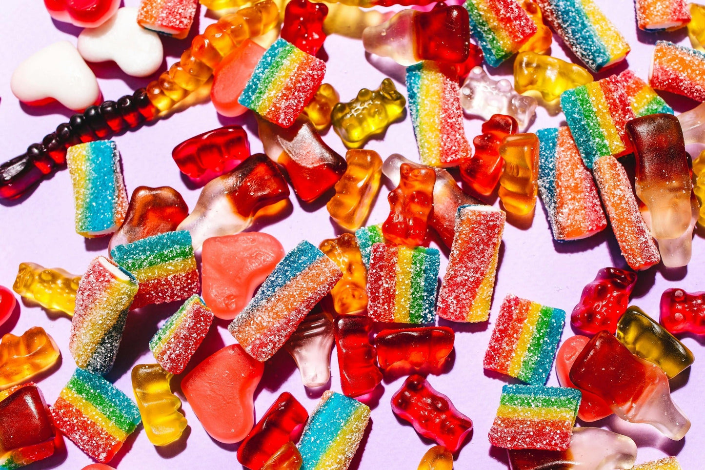 Assorted colourful gummy sweets on a pastel background